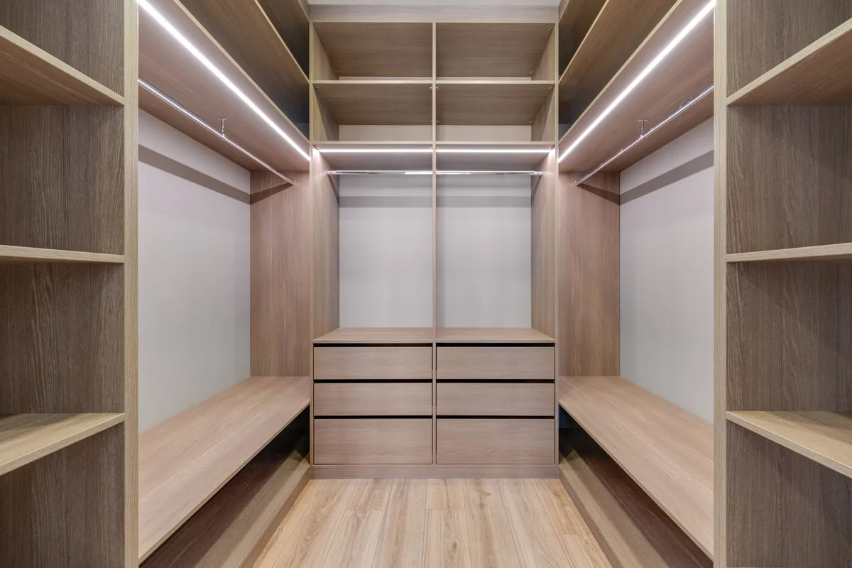 Intérieur de dressing avec éclairage LED et rangements bien organisés par zones