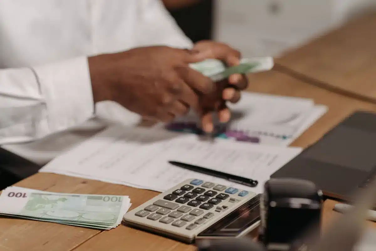Dossiers d'épargne et calculatrice illustrant l'apport personnel pour un achat immobilier