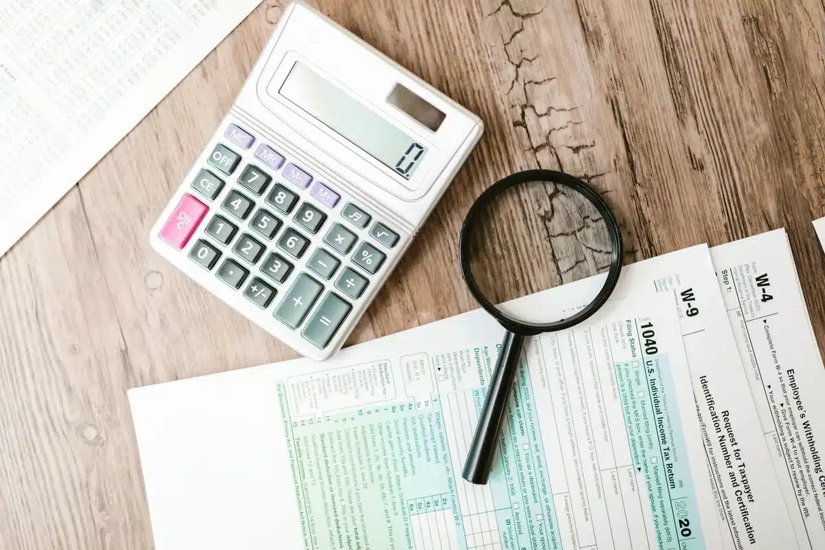 Documents financiers et calculatrice montrant l'évaluation de la capacité de financement par une banque
