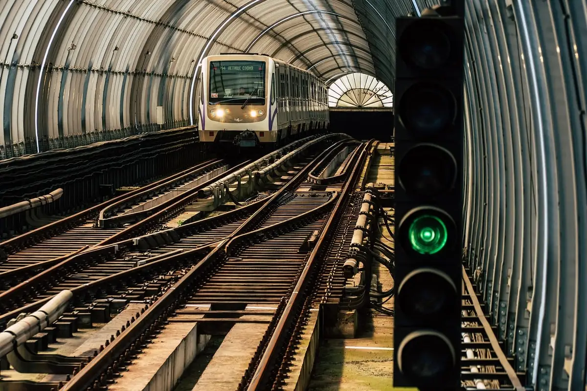 Gare de banlieue avec un train et voyageurs en journée